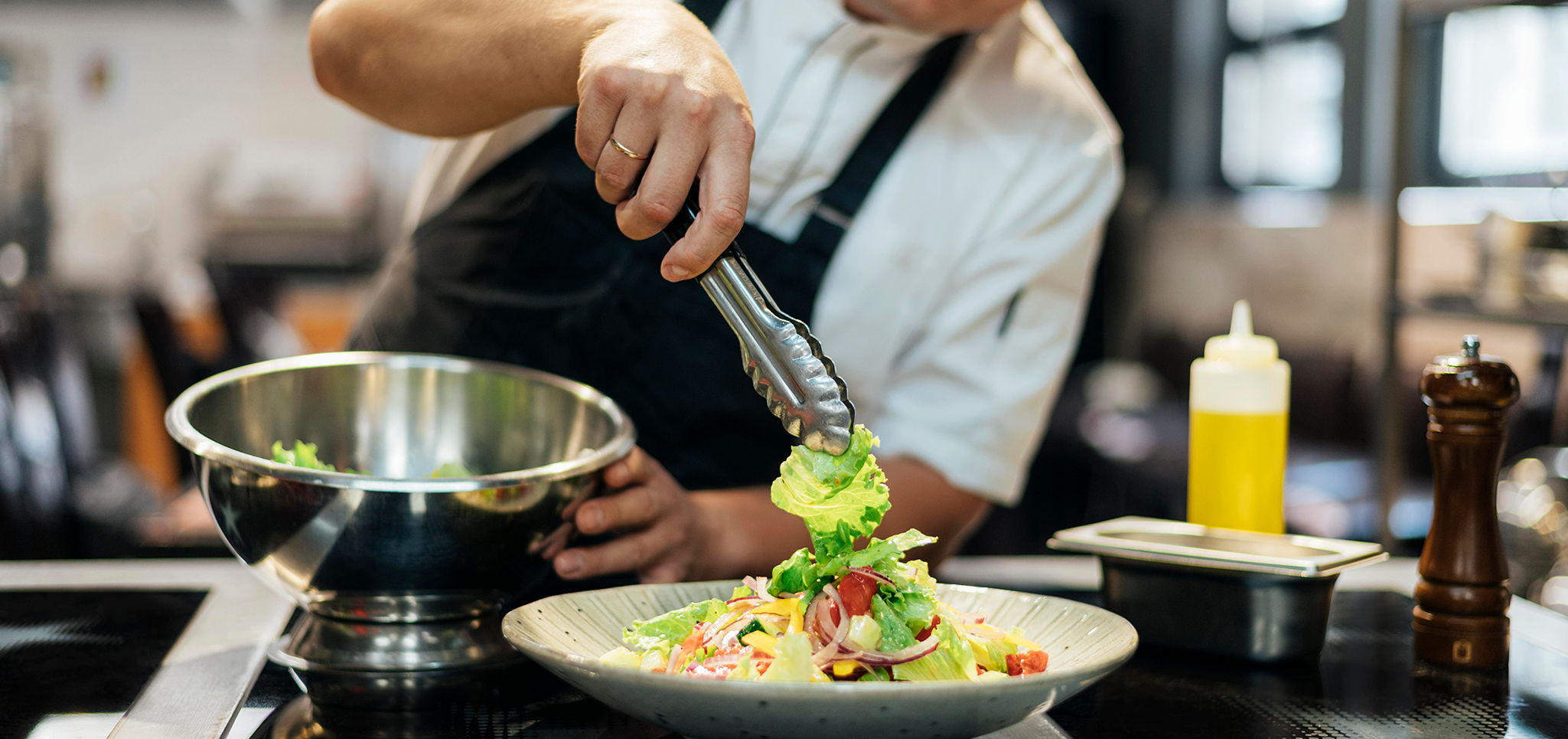 male-chef-putting-salad-on-plate copiar